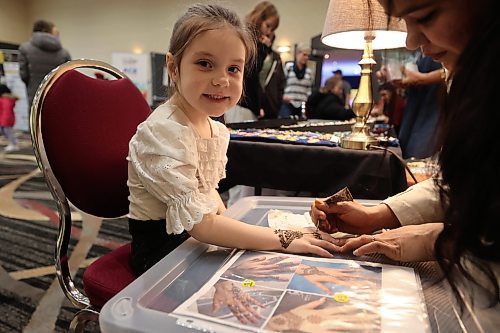 Briar Hislop smiles as an artist design Henna tattoo, Indian traditional tattoo, on her hand Saturday afternoon. (Abiola Odutola/The Brandon Sun)