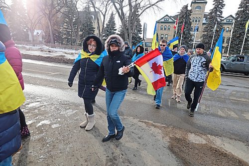 Ukrainians based in Brandon and residents cross 18th street in front of Brandon University during the solidarity march to the City hall in with Ukraine reaching its three-years mark of war. (Abiola Odutola/The Brandon Sun)