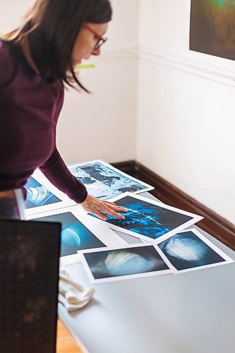 MIKE DEAL / FREE PRESS
Brenda Stuart is a photographer who specializes in solargraphy, a photographic method using a pinhole camera to capture the path of the sun. This is a form of pinhole photography using a long-exposure technique where the arc of the sun&#x2019;s trails are recorded onto photographic paper as the sun&#x2019;s position in the sky changes from solstice to solstice. Images can be made over a day, a week, a month, a year. Or even longer. A clear sunny day will record a strong bright arc across the photo paper. When the days are cloudy or partially cloudy the camera records dots and dashes.
Brenda in her studio with examples of her work that have been scanned and printed for exhibition.
Reporter: AV Kitching
250225 - Tuesday, February 25, 2025.