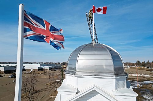12032025
Corbin Mariash with Brandon Fire and Emergency Services replaces a Canadian flag atop one of the domes at The Dome Building in Brandon on Wednesday afternoon. BFES members took turns at the top of a ladder truck replacing multiple flags at The Dome Building. 
(Tim Smith/The Brandon Sun)