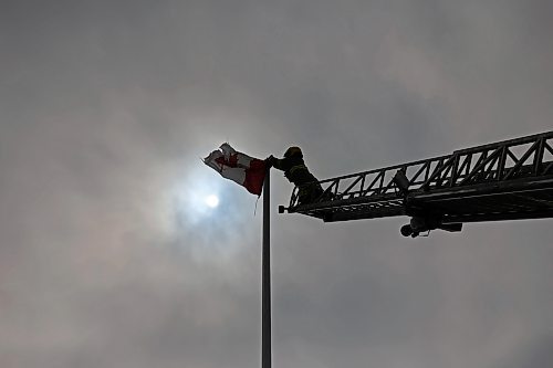 12032025
Devin Gellatly with Brandon Fire and Emergency Services replaces a Canadian flag atop The Dome Building in Brandon on Wednesday afternoon. BFES members took turns at the top of a ladder truck replacing multiple flags at The Dome Building. 
(Tim Smith/The Brandon Sun)default