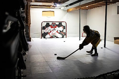 MIKAELA MACKENZIE / FREE PRESS
	

The boy who has been suspended from all hockey related activities in south Winnipeg by the South Winnipeg Hockey Association (due to his parents filing a defamation lawsuit against the association) shoots pucks in his basement training area on Friday, March 14, 2025. 

For Scott story.
Winnipeg Free Press 2025