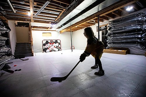 MIKAELA MACKENZIE / FREE PRESS
	

The boy who has been suspended from all hockey related activities in south Winnipeg by the South Winnipeg Hockey Association (due to his parents filing a defamation lawsuit against the association) shoots pucks in his basement training area on Friday, March 14, 2025. 

For Scott story.
Winnipeg Free Press 2025