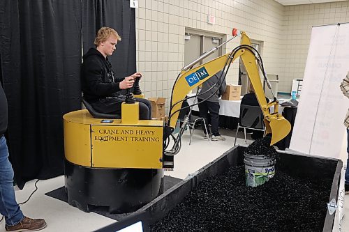 Rivers Collegiate grade 10 student Winston Lepp operates an excavator assimilator at the Operating Engineers Training Institute of Manitoba's booth during the Brandon Career Symposium Keystone Centre Tuesday afternoon. (Abiola Odutoila/The Brandon Sun)