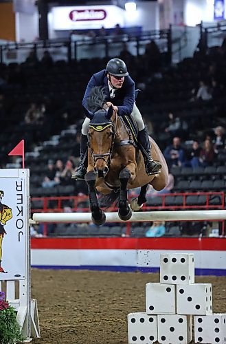 Jeremy Ockey, riding Castlefield Confellow, jumps the Joker hurdle during the Gambler's Choice show riding event on Monday evening. (Matt Goerzen/The Brandon Sun)