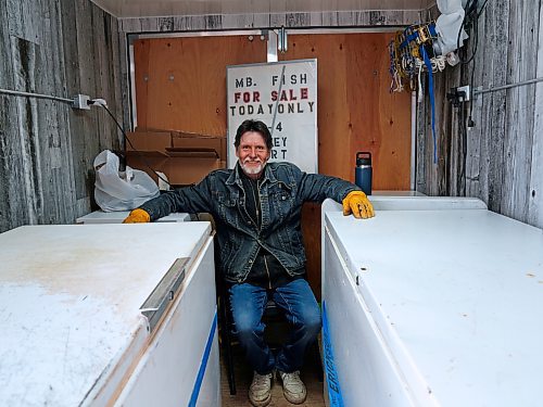 Chris Robinson sits between his freezers in the family's mobile fish store in the parking lot at the Riverbank Discovery Centre in Brandon on Wednesday. All the fish, caught in March near the family's home at Matheson Island on lake Winnipeg, had sold out by late morning, he said. (Weichen Zhang/The Brandon Sun)