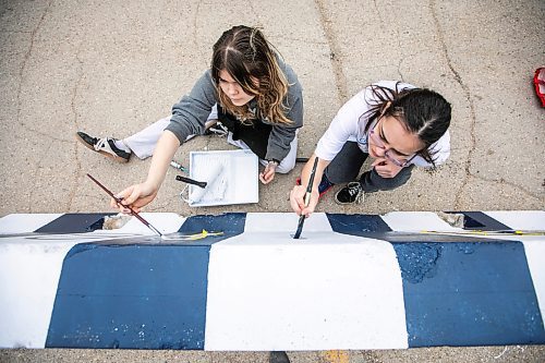 MIKAELA MACKENZIE / FREE PRESS
Hugh John MacDonald School grade nine students Athena Abuda (left) and Charisma Wozny paint a concrete barrier ahead of the whiteout street parties near Donald and Graham on Thursday, April 17, 2025.
Winnipeg Free Press 2025
