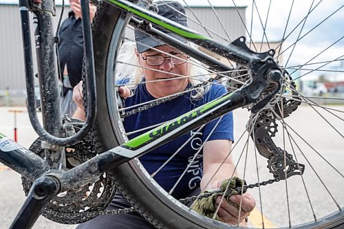 Daniel Crump / Winnipeg Free Press. Mark Cohoe tunes up a bike during the free bike tune-up clinic hosted by CAA Manitoba and Bike Winnipeg at 987 Milt Stegall Dr. on Saturday. May 28, 2022.
