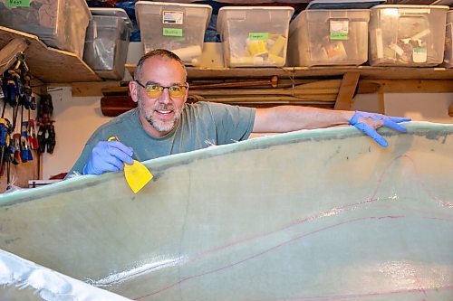 BROOK JONES/FREE PRESS
Paddle and Hum owner Myron Sawatzky builds lightweight solo canoes in a backyard shed he converted into his workshop. The North Kildonan resident is pictured appling epoxy resin to the interior hull of a fiberglass canoe he is building in his workhop in Winnipeg, Man., Monday, May 5, 2025.