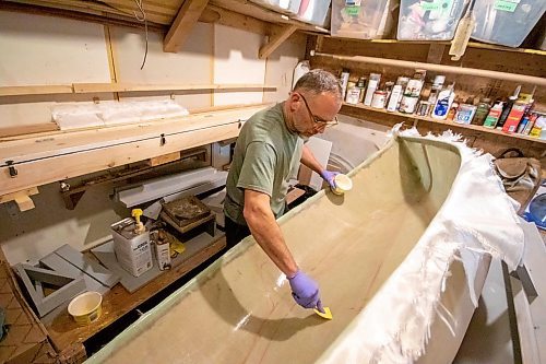 BROOK JONES/FREE PRESS
Paddle and Hum owner Myron Sawatzky builds lightweight solo canoes in a backyard shed he converted into his workshop. The North Kildonan resident is pictured appling epoxy resin to the interior hull of a fiberglass canoe he is building in his workhop in Winnipeg, Man., Monday, May 5, 2025.