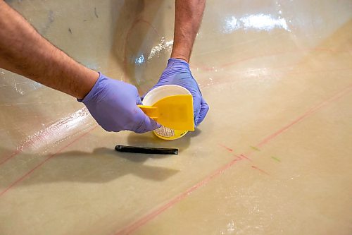 BROOK JONES/FREE PRESS
Paddle and Hum owner Myron Sawatzky builds lightweight solo canoes in a backyard shed he converted into his workshop. The North Kildonan resident is pictured appling epoxy resin to the interior hull of a fiberglass canoe he is building in his workhop in Winnipeg, Man., Monday, May 5, 2025.