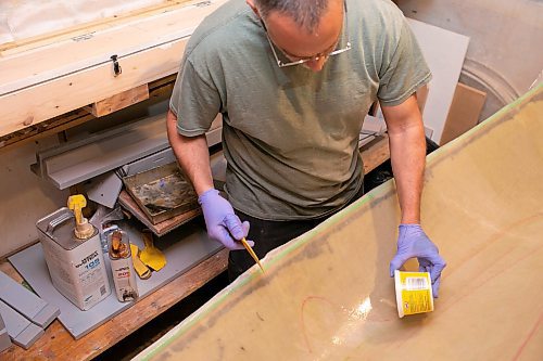 BROOK JONES/FREE PRESS
Paddle and Hum owner Myron Sawatzky builds lightweight solo canoes in a backyard shed he converted into his workshop. The North Kildonan resident is pictured appling epoxy resin to the interior hull of a fiberglass canoe he is building in his workhop in Winnipeg, Man., Monday, May 5, 2025.