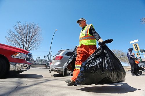 City of Brandon sanitation employee Andrew Green carries three bags of garbage that he collected as part of the Spring Downtown Community Clean-Up Day on Wednesday afternoon. More than 100 people were estimated to have volunteered their time on Wednesday to help clean up the downtown, including City staff. (Matt Goerzen/The Brandon Sun)