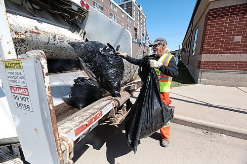 City of Brandon sanitation employee Andrew Green dumps bags of garbage that he collected into the back of a collection truck as part of the Spring Downtown Community Clean-Up Day on Wednesday afternoon. More than 100 people were estimated to have volunteered their time on Wednesday to help clean up the downtown, including City staff. (Matt Goerzen/The Brandon Sun)