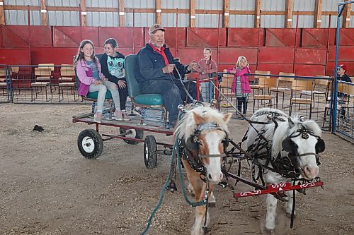 Danny Siwaluk (front) gives Amelia Coey, 8, (left) and Jessica Gerrard, 9, a ride on his “Small But Mighty” 40-inch pony chore team on Saturday afternoon during the Minnedosa Agricultural Society’s Spring Market & Tack Sale held at the town's Agricultural Complex. Photos: Abiola Odutola/The Brandon Sun