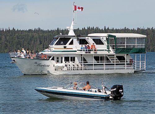 In this file photo, the Martese cruise boat sails into the pier at Clear Lake beach past a motorboat at the main beach in Wasagaming during an August long weekend. Parks Canada announced Friday that all motorized craft would be banned from the lake this season, after saying in January that they would be allowed. (Brandon Sun files)