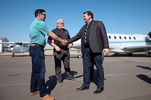 Simard greets Clayton Canart, reeve for the RM of Wallace-Woodworth, and Scott Andrew, president and accountable executive at Air Andrew, after Monday's announcement. (Tim Smith/The Brandon Sun)