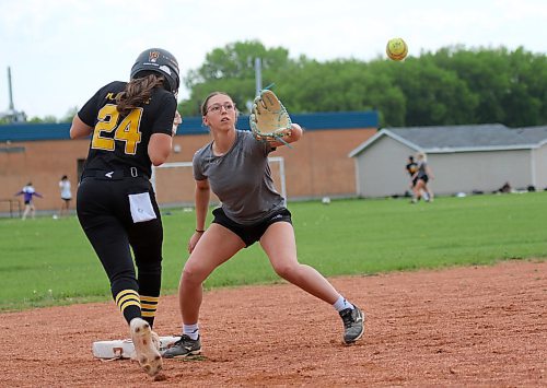 Caitlan Nickel, right, catches a throw to third base as Quinn Twordik runs back to the bag. (Thomas Friesen/The Brandon Sun)