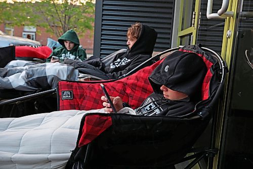 28052025
Owen Stanley waits with friends at sunrise early Wednesday morning for the doors of Guild Insurance Group on Victoria Avenue to open so they can register for the Driver Z provincial driver's education program. Stanley and four friends were the first in line at Guild Insurance, arriving yesterday evening and camping out overnight to secure their spots in the program. By sunrise the line of students and parents wrapped around two sides of the building, with many having arrived overnight. Many parents and teens are frustrated that Manitoba Public Insurance is not meeting the demand for the program.
(Tim Smith/The Brandon Sun)
