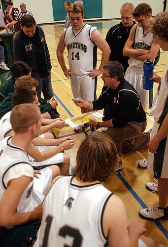 Legacy Brandon Sun BRUCE BUMSTEAD/BRANDON SUN Spartans' coach Don Thomson works over a game plan with his players during a time-out during Thursday's Brandon Sun Spartan Invitation basketball tournament at Neelin.