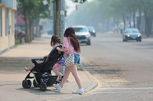 Residents walk on Princess Ave, on Saturday morning as smoke thickens. (Abiola Odutola/The Brandon Sun)