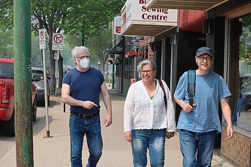 A resident wears a nose mask walks with two others along Princess Ave. on Saturday morning as smoke hangs thick in the air. (Abiola Odutola/The Brandon Sun)