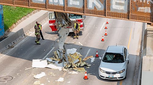 MIKE DEAL / FREE PRESS
WFPS and WPS examine the remains of the roof of a trailer that was attached to a semi-truck as it hangs from the railway bridge over Portage Avenue close to Polo Park Shopping Centre.
Standup
250603 - Tuesday, June 03, 2025.