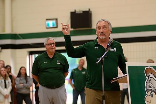 Carey Lasuik, right, points to the banners lining the Neelin gymnasium walls while recognizing the coach he worked alongside for 12 years of varsity basketball. (Thomas Friesen/The Brandon Sun)