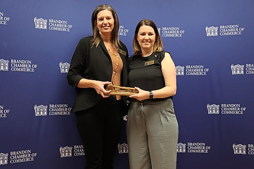 Outgoing president Lois Ruston (left) hands over the gavel to new president Jennifer Ludwig on Thursday at the Clarion Hotel. (Abiola Odutola/The Brandon Sun)