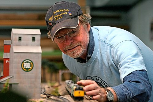 MIKE DEAL / WINNIPEG FREE PRESS 071114 Morgan Turney a member of the Winnipeg Model Railway Club places an engine on the track of the WMRC Gateway Western Railroad in the basement of Gooches. The track there can be used by any member who doesn't have one of their own. The Wpg. Model Railway Club is about more than just the trains, designing and building dioramas can be a major part of the hobby.