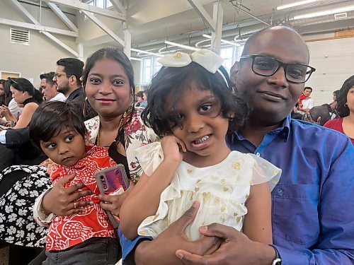 Robin Samson (right), holding his daughter, Raelynn Samson, and wife Anjali Arumugam, holding son Remiel Samson, wait for the citizenship ceremony to begin. (Matt Goerzen/The Brandon Sun)