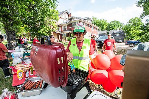 MIKAELA MACKENZIE / WINNIPEG FREE PRESS
	
Cyclist Anna Weier flips hot dogs and holds balloons at a community-led block party honouring Rob Jennerճ life on Wellington Crescent and Cockburn Street on Friday, June 6, 2025. 

For Matt story.
Winnipeg Free Press 2025