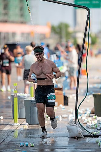 BROOK JONES/FREE PRESS
A full marathoner cools off under a makeshift shower at a fluids station while hitting the 32km mark along Pembina Highway as he competes the 47th Manitoba Marathon in Winnipeg, Man., Sunday, June 15, 2025.