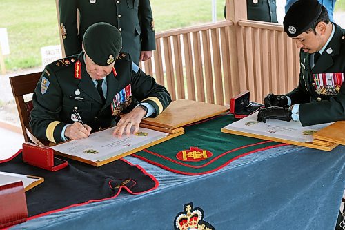 Brigadier-General R.D. Dove signs for a change of command at CFB Shilo along with Lieutenant-Colonel J.P. Nguyen and (not pictured) Lieutenant-Colonel D.R. Cronk on June 25. The ceremony took place to formally transfer base command to Nguyen from Cronk. (Connor McDowell/Brandon Sun)