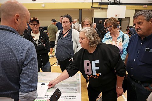 25062025
RM of North Cypress-Langford resident Debra Steen, one of the organizers of the local opposition to the proposed RCUT modification to the Trans Canada Highway at the Highway 5 intersection, hands over a petition with 1200 signatures to representatives from Landmark Planning & Design, WSP and the province at the fourth community engagement meeting at Carberry Collegiate on Wednesday evening.
(Tim Smith/The Brandon Sun)