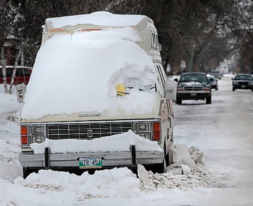 Residential Parking Ban. A vehicle on Amherst St. in St. James is ticketed as snow cleaning carried on around it. Wayne Glowacki / Winnipeg Free Press Dec.12. 2013