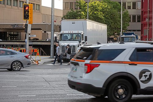 MIKE DEAL / FREE PRESS
construction crews remove the last of the barriers while impatient pedestrians cross the street at Portage Avenue and Main Street just hours before they officially open Friday morning. 
20250627 - June 27, 2025
