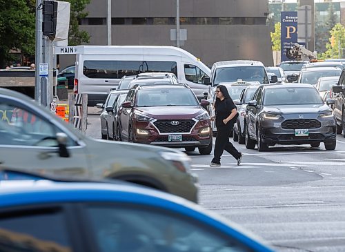 MIKE DEAL / FREE PRESS
construction crews remove the last of the barriers while impatient pedestrians cross the street at Portage Avenue and Main Street just hours before they officially open Friday morning.
20250627 - June 27, 2025