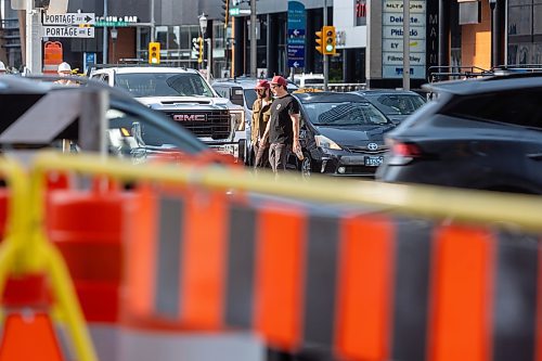 MIKE DEAL / FREE PRESS
Construction crews remove the last of the barriers while impatient pedestrians cross the street at Portage Avenue and Main Street just hours before they officially open Friday morning.
20250627 - June 27, 2025