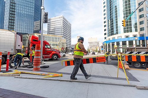 MIKE DEAL / FREE PRESS
construction crews remove the last of the barriers while impatient pedestrians cross the street at Portage Avenue and Main Street just hours before they officially open Friday morning. 
20250627 - June 27, 2025