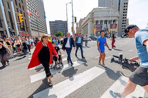MIKE DEAL / FREE PRESS
Mayor Scott Gillingham along with several city council members and stakeholders cross Main Street to mark the official opening of the pedestrian crosswalks.
The day of the official opening of the pedestrian crosswalks at the historic intersection of Portage Avenue and Main Street started with crews clearing away the last of the barriers and impatient people crossing despite those barriers.
The Mayor, Scott Gillingham and several city council members, along with may of the stakeholders for the buildings at each of the corners of the intersection were on hand with several hundred members of the public who cam to cheer and be some of the first to cross after the opening.
Dancing Gabe was on hand to lead a huge crowd around each of the intersections.
Reporter: Tyler Searle
250627 - Friday, June 27, 2025.