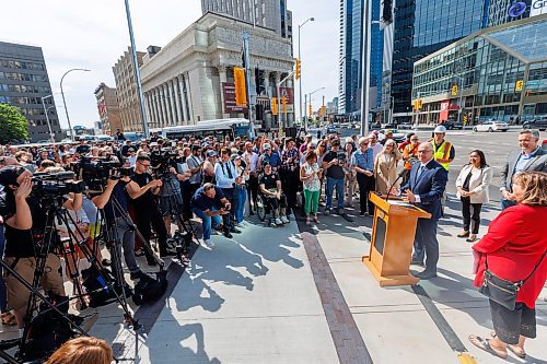 MIKE DEAL / FREE PRESS
Mayor Scott Gillingham speaks to the assembled crowd before walking across the street making the official opening of the pedestrian crosswalks.
The day of the official opening of the pedestrian crosswalks at the historic intersection of Portage Avenue and Main Street started with crews clearing away the last of the barriers and impatient people crossing despite those barriers.
The Mayor, Scott Gillingham and several city council members, along with may of the stakeholders for the buildings at each of the corners of the intersection were on hand with several hundred members of the public who cam to cheer and be some of the first to cross after the opening.
Dancing Gabe was on hand to lead a huge crowd around each of the intersections.
Reporter: Tyler Searle
250627 - Friday, June 27, 2025.