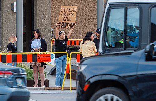 MIKE DEAL / FREE PRESS
Haley Yurman, brand and marketing leader for Empty Cup which has a storefront in the underground concourse at Portage and Main, holds up a sign reminding people that they still exist.
The day of the official opening of the pedestrian crosswalks at the historic intersection of Portage Avenue and Main Street started with crews clearing away the last of the barriers and impatient people crossing despite those barriers.
The Mayor, Scott Gillingham and several city council members, along with may of the stakeholders for the buildings at each of the corners of the intersection were on hand with several hundred members of the public who cam to cheer and be some of the first to cross after the opening.
Dancing Gabe was on hand to lead a huge crowd around each of the intersections.
Reporter: Tyler Searle
250627 - Friday, June 27, 2025.