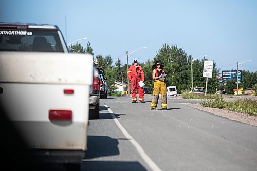 MIKAELA MACKENZIE / FREE PRESS
	
Firefighters hand leaflets with support information out to evacuees returning in Flin Flon on Wednesday, June 25, 2025.

For Nicole Buffie story.
Winnipeg Free Press 2025