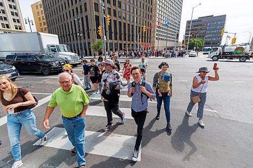 MIKE DEAL / FREE PRESS
Once crossing the street at Portage and Main became official huge crowds of people make their way around to each of the crosswalks.
The day of the official opening of the pedestrian crosswalks at the historic intersection of Portage Avenue and Main Street started with crews clearing away the last of the barriers and impatient people crossing despite those barriers.
The Mayor, Scott Gillingham and several city council members, along with may of the stakeholders for the buildings at each of the corners of the intersection were on hand with several hundred members of the public who cam to cheer and be some of the first to cross after the opening.
Dancing Gabe was on hand to lead a huge crowd around each of the intersections.
Reporter: Tyler Searle
250627 - Friday, June 27, 2025.