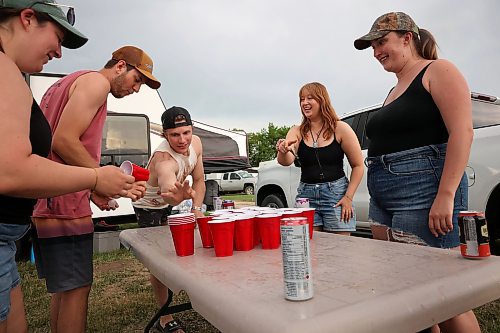 A group of friends from Winnipeg play a game called stack cup at their campsite on Friday. (Tim Smith/The Brandon Sun)