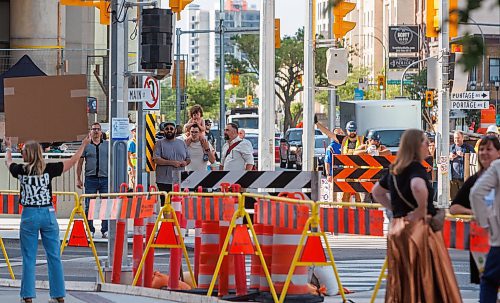 MIKE DEAL / FREE PRESS
Families with small children arrive to be among the first since 1979 to legally cross the street. Though because the crossings were not open yet, they decided to cross anyways.
The day of the official opening of the pedestrian crosswalks at the historic intersection of Portage Avenue and Main Street started with crews clearing away the last of the barriers and impatient people crossing despite those barriers.
The Mayor, Scott Gillingham and several city council members, along with may of the stakeholders for the buildings at each of the corners of the intersection were on hand with several hundred members of the public who cam to cheer and be some of the first to cross after the opening.
Dancing Gabe was on hand to lead a huge crowd around each of the intersections.
Reporter: Tyler Searle
250627 - Friday, June 27, 2025.