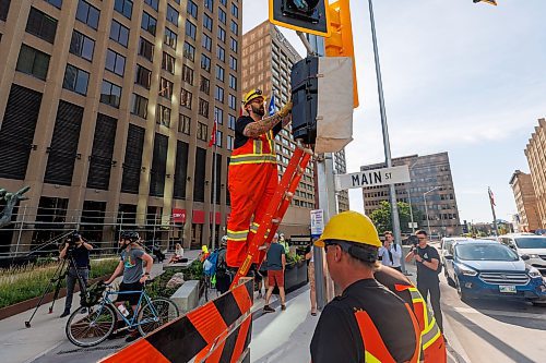 MIKE DEAL / FREE PRESS
The day of the official opening of the pedestrian crosswalks at the historic intersection of Portage Avenue and Main Street started with crews clearing away the last of the barriers and impatient people crossing despite those barriers.
The Mayor, Scott Gillingham and several city council members, along with may of the stakeholders for the buildings at each of the corners of the intersection were on hand with several hundred members of the public who cam to cheer and be some of the first to cross after the opening.
Dancing Gabe was on hand to lead a huge crowd around each of the intersections.
Reporter: Tyler Searle
250627 - Friday, June 27, 2025.