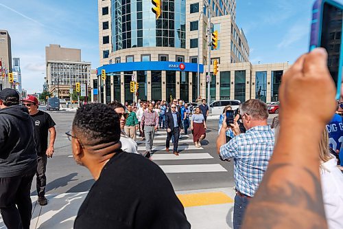 MIKE DEAL / FREE PRESS
Once the barriers and signage was taken down, huge numbers of pedestrians took the opportunity to cross Main Street.
The day of the official opening of the pedestrian crosswalks at the historic intersection of Portage Avenue and Main Street started with crews clearing away the last of the barriers and impatient people crossing despite those barriers.
The Mayor, Scott Gillingham and several city council members, along with may of the stakeholders for the buildings at each of the corners of the intersection were on hand with several hundred members of the public who cam to cheer and be some of the first to cross after the opening.
Dancing Gabe was on hand to lead a huge crowd around each of the intersections.
Reporter: Tyler Searle
250627 - Friday, June 27, 2025.