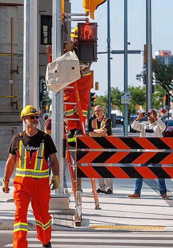 MIKE DEAL / FREE PRESS
The day of the official opening of the pedestrian crosswalks at the historic intersection of Portage Avenue and Main Street started with crews clearing away the last of the barriers and impatient people crossing despite those barriers.
The Mayor, Scott Gillingham and several city council members, along with may of the stakeholders for the buildings at each of the corners of the intersection were on hand with several hundred members of the public who cam to cheer and be some of the first to cross after the opening.
Dancing Gabe was on hand to lead a huge crowd around each of the intersections.
Reporter: Tyler Searle
250627 - Friday, June 27, 2025.